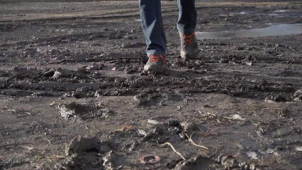 Man in Boots Walks Through the Mud Splashing From a Puddle in Slowmo