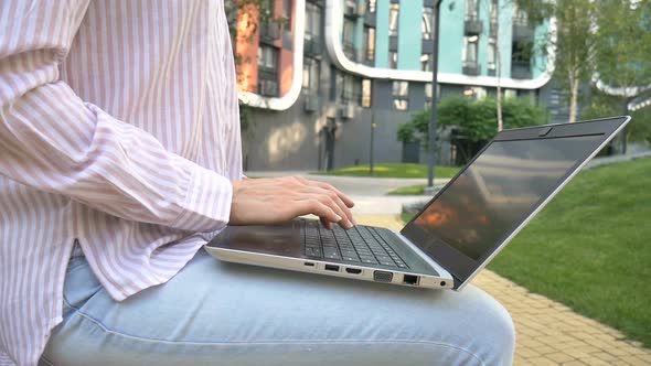 Young Woman Typing on Keyboard of Laptop Businesswoman Using Digital Tablet Outside on Modern