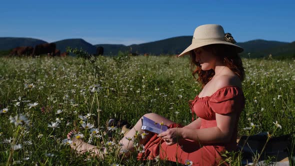 Beautiful Young Woman in Chamomile Field