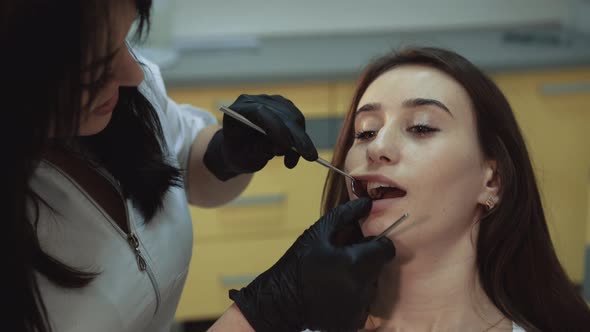 Young Pretty Girl Sits in Dental Cabinet on Treatment and Consultating