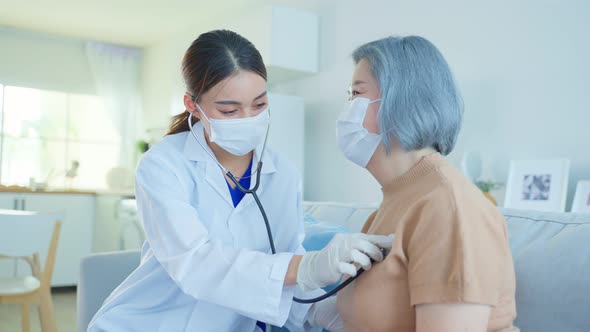 Asian doctor or nurse wear face mask give treatment to Senior elderly woman disabled patient.