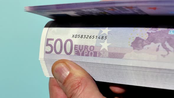 These hands hold a lot of money, and with their thumbs, the holder can flip through these euro notes