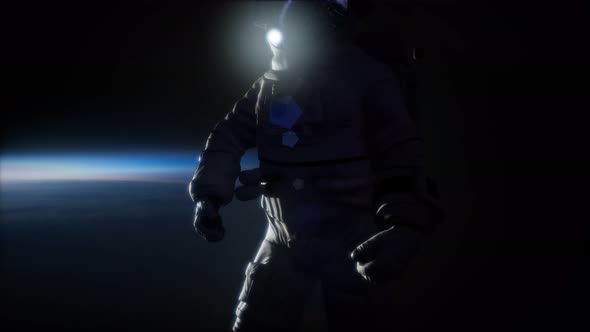 Astronaut in Outer Space Against the Backdrop of the Planet Earth