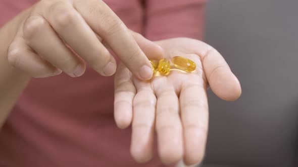 Young woman with medicine on her palm for use.