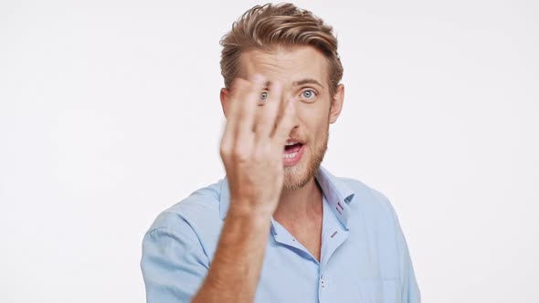 Beautiful Young Caucasian Male with Blue Eyes and Brown Hair Sending Two Air Kisses to Camera on