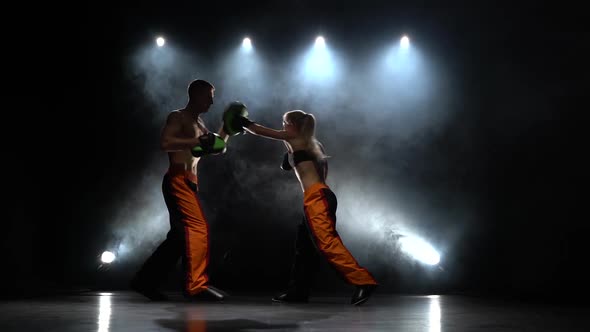 Development of Straight Kicks Kickboxing on Boxing Paws. Light From Behind. Smoke Background