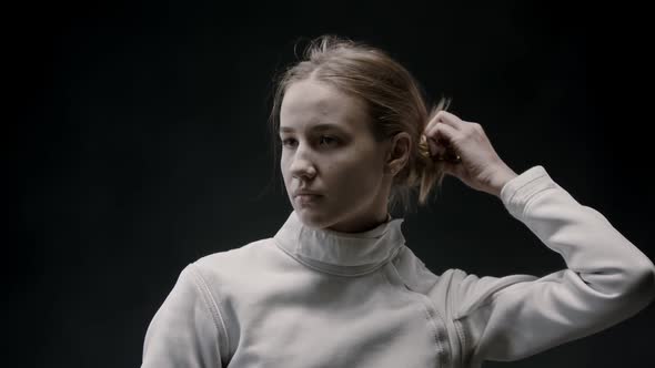 A Young Woman Fencer Lets Her Hair Down