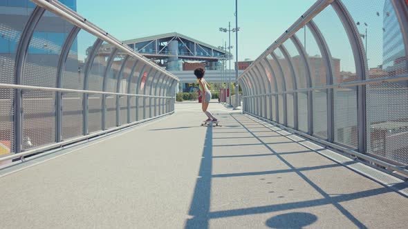 Beautiful young woman cruising around the city with her longboard.