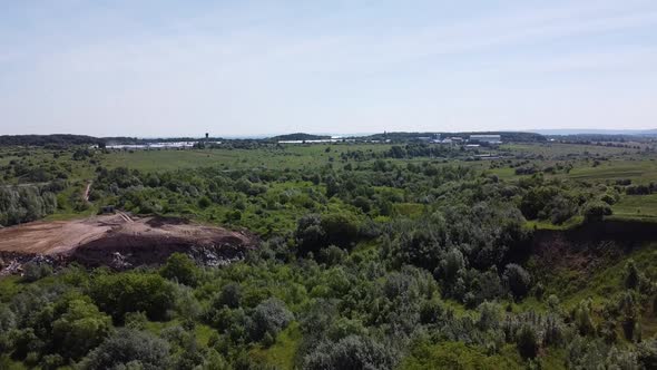 Aerial drone view of a flying over the technogenic landscape among rural agricultural fields.