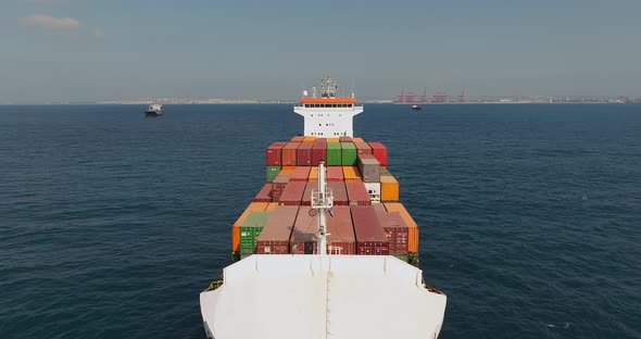 Container ship loaded with Shipping containers holding position at sea.