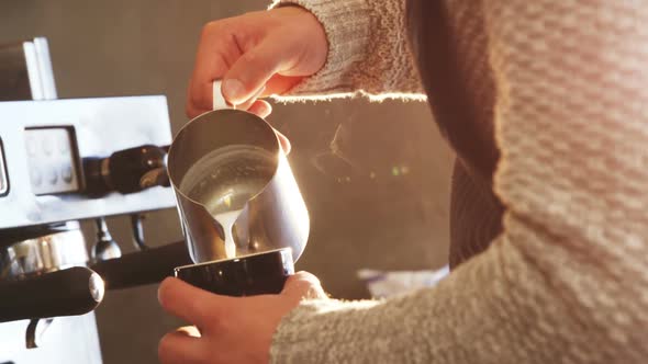 Waiter making cup of coffee in cafe