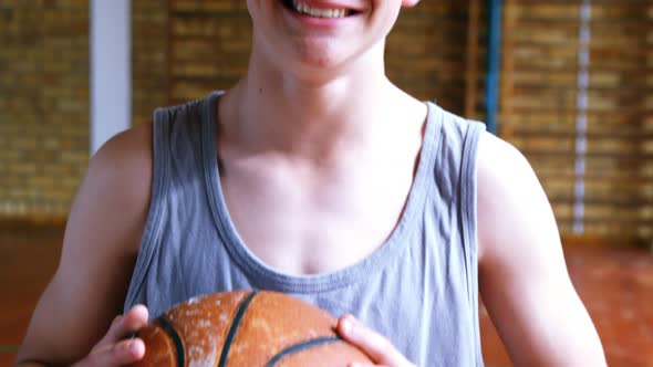 Schoolboy standing with basketball in court 4k