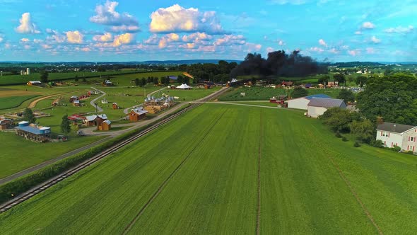 Aerial View of Amish Farm lands With a Single Rail Road Track and a Steam Passenger Train
