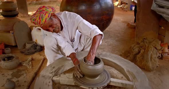 Skilled Professional Potter Throwing the Potter's Wheel and Shaping Traditional Ceramic Vessel and