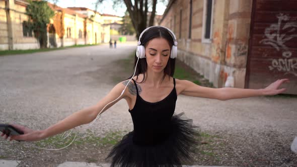 Young Ballerina Dancing In Courtyard While Listening To Music