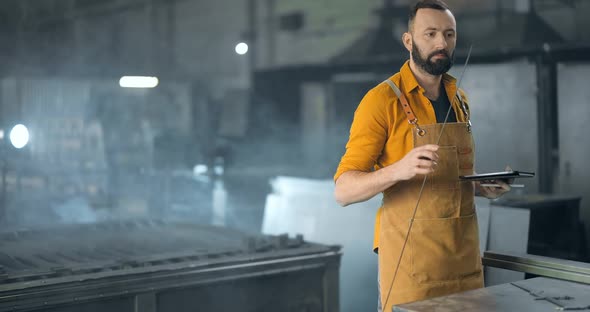 Factory Worker with Tablet and Phone at the Manufacturing