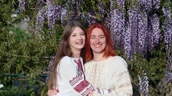 Girlfriends in National Traditional Clothes Vyshyvanka Hug and Smile in Nature