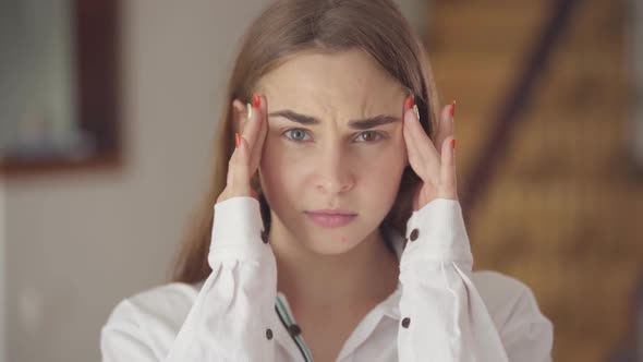 Portrait of Pretty Girl with Heterochromia with Headache Massaging Her Head with Fingers