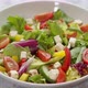 Colorful Fresh Vegetable Salad with Feta Cheese in a White Deep Bowl Closeup on a Stone Table - VideoHive Item for Sale