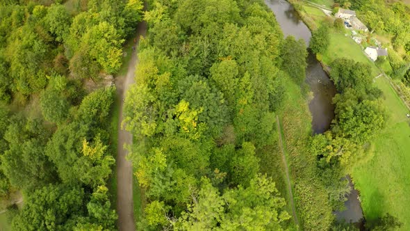 Aerial view of cyclists riding through the forest, woods by Headstone viaduct, bridge in the Derbysh