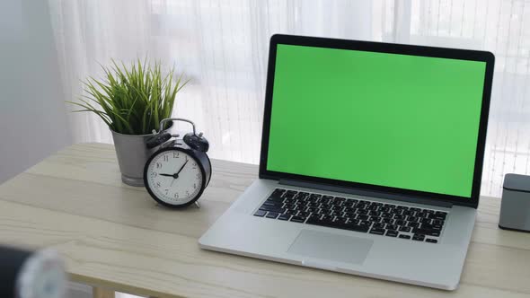 Slide shot, Chroma key green screen of laptop computer set on working space in home office.