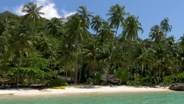 White sandy beach with coconut palm trees. Koh Kood, Thailand. ZOOM OUT