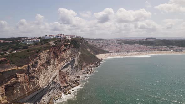 Aerial panoramic view Nazaré coastline, village and endless sandy beach - Portugal