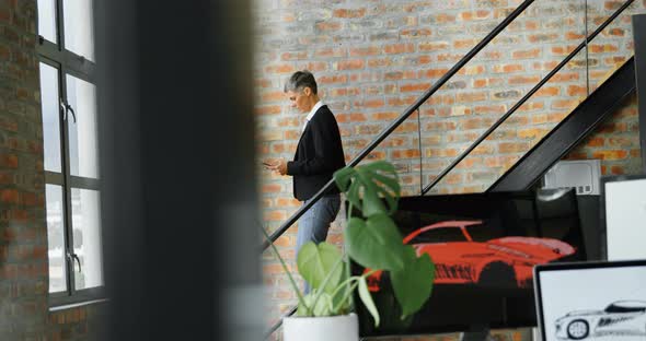 Businesswoman using digital tablet while descending staircase 