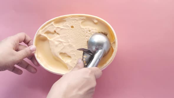 Hand Picking Ice Cream with a Spoon From a Bowl