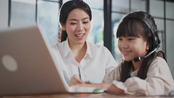 Homeschool Asian little young girl learning online class from school teacher by digital remote class