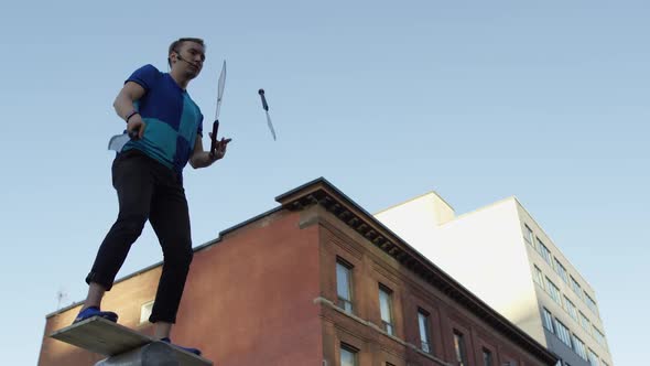 Juggler in city using swords in slow motion