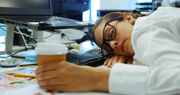 Female graphic designer sleeping at desk
