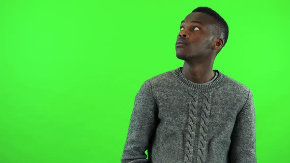 A Young Black Man Covers His Eyes with His Hands and Looks Around in Confusion - Green Screen Studio