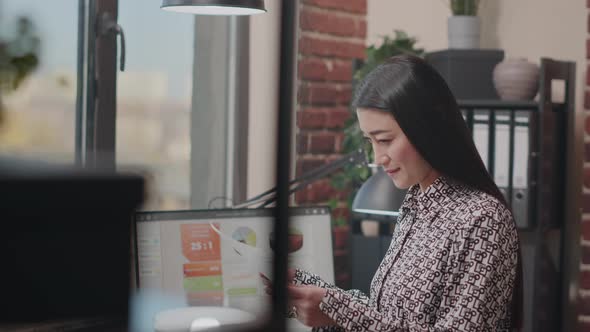 Company Employee Looking at Papers and Computer