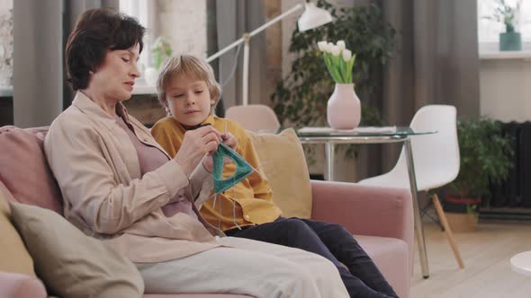 Grandmother Knitting While Grandson Watching