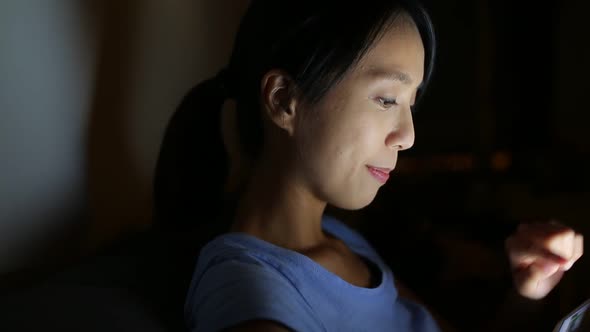 Woman using digital tablet at night