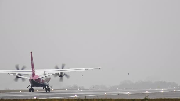The Plane Travels on the Runway in Rainy Weather