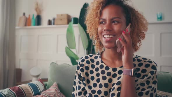 Happy African American Woman Feels Pleasantly Excited While Talking on Phone