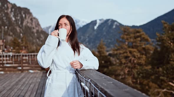 Young Beautiful Woman Standing Having Breakfast Outdoors with Cup Coffee and Admiring Natural