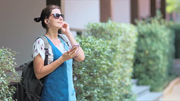 Young Beautiful Woman Listening to the Music Dancing and Singing in the Park