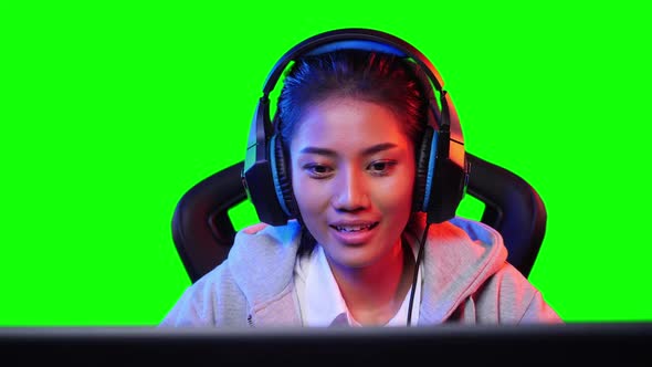 Gamer woman playing video game with green screen