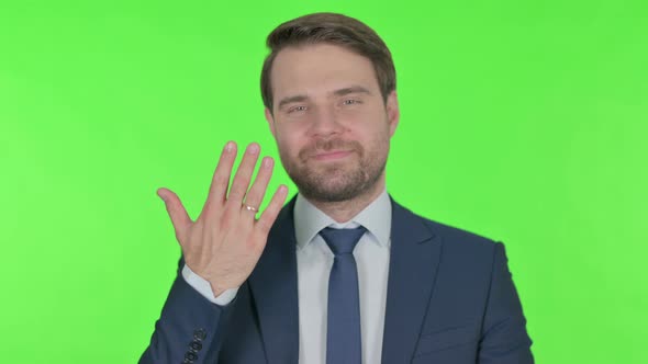 Happy Young Businessman showing Marriage Ring on Finger on Green Background