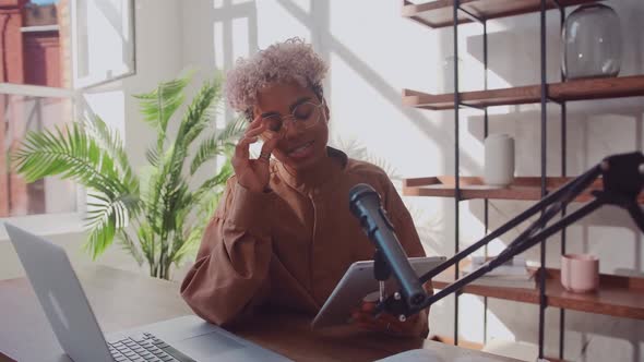 Cheerful African American Woman Podcaster Records Her Voice Into a Microphone