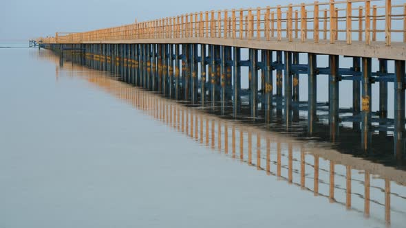 Static shot of jetty and its reflection on sea waters