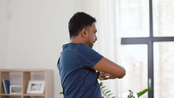 Man with Fitness Tracker Stretching Waist at Home