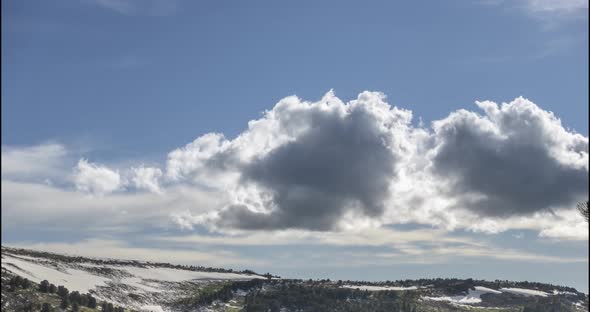 Time Lapse of Cloudscape Behind of the Mountains Top. Snow, Rocks, Cliffs and Deep Blue Sky. High