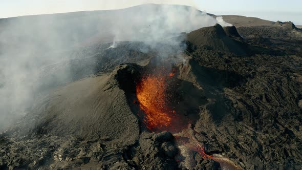 Orbiting Geldingadalir Volcano crater, burning and spewing fountain of hot lava during sunlight.