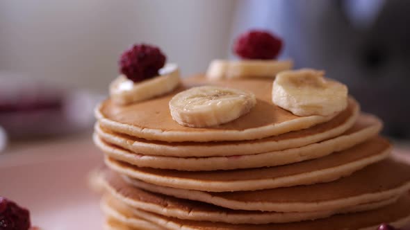 Closeup Kid's Hand Putting Raspberries on Pancake