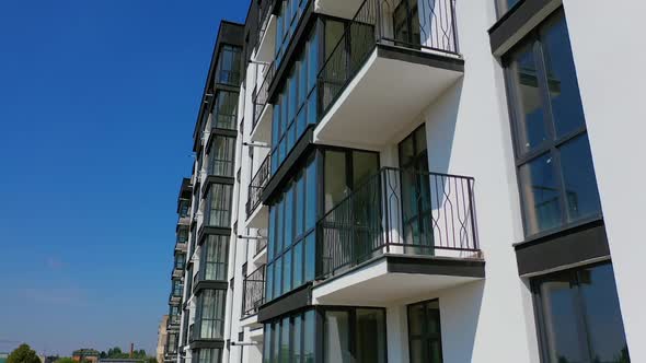 Beautiful design of multistorey building. New apartment with balconies against blue sky. 