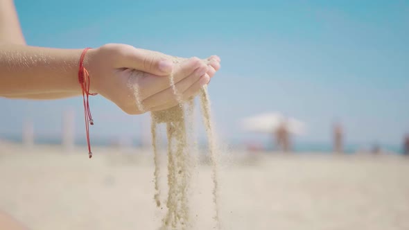 Sand As the Time Slips Through Your Fingers. Little Girl Holding a Sand Sea Background. Sand in Your